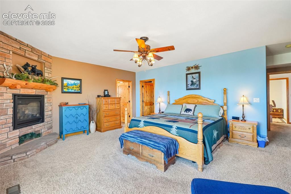 Image 27 of 50: Primary bedroom on lower level with a private walk out deck, a gas fireplac