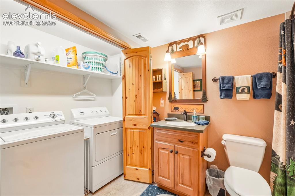 Image 42 of 50: Full bathroom with laundry near bedroom 3 on lower level
