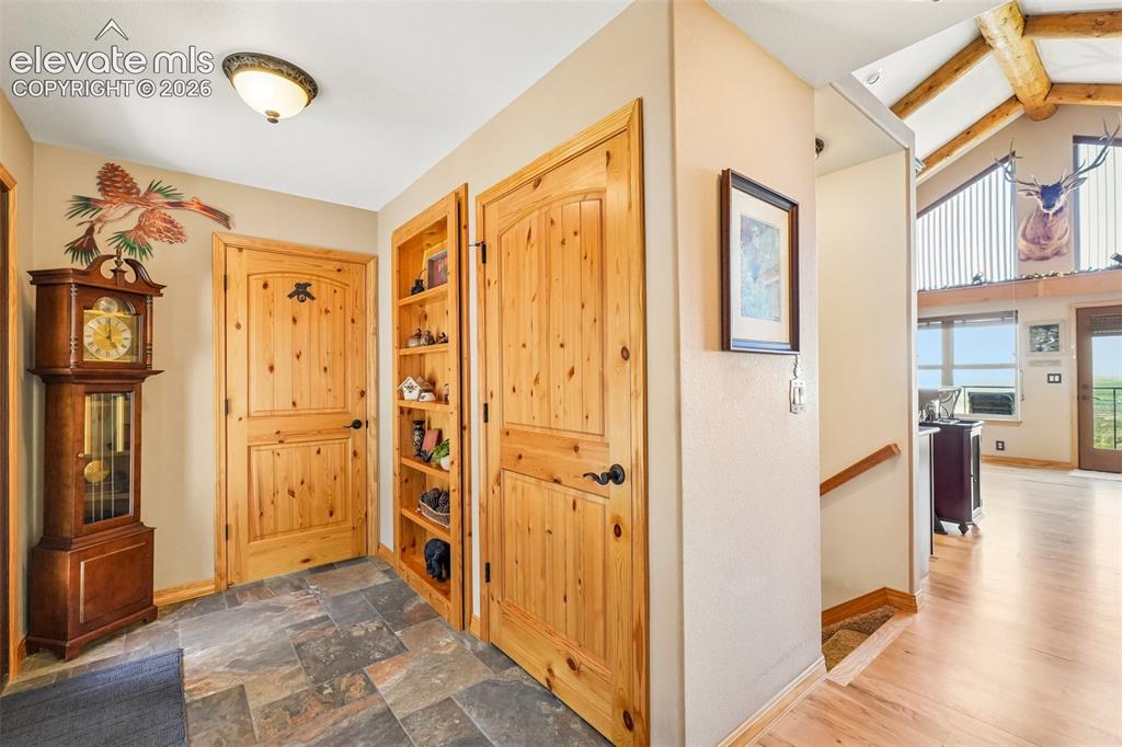 Image 6 of 50: Grand foyer with knotty pine doors and trim