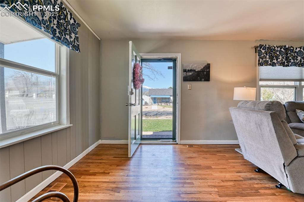 Image 8 of 47: Doorway with baseboards and wood finished floors