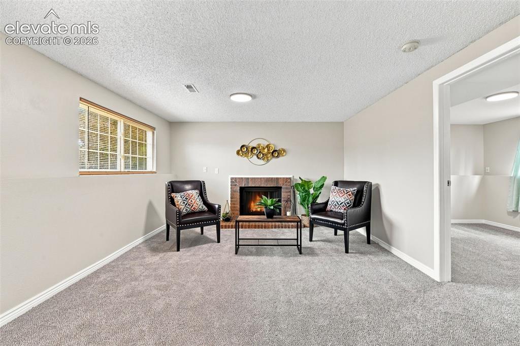 Image 22 of 33: Lower Level Family room area around wood burning fireplace.