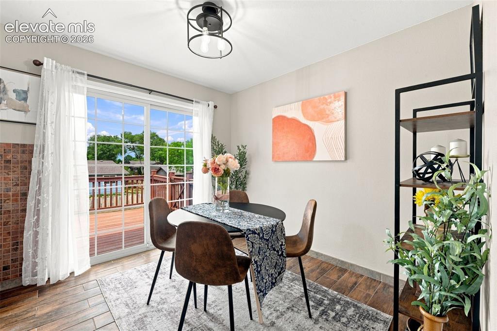 Image 4 of 33: Dining area with view out sliding door to back deck also new light fixture.