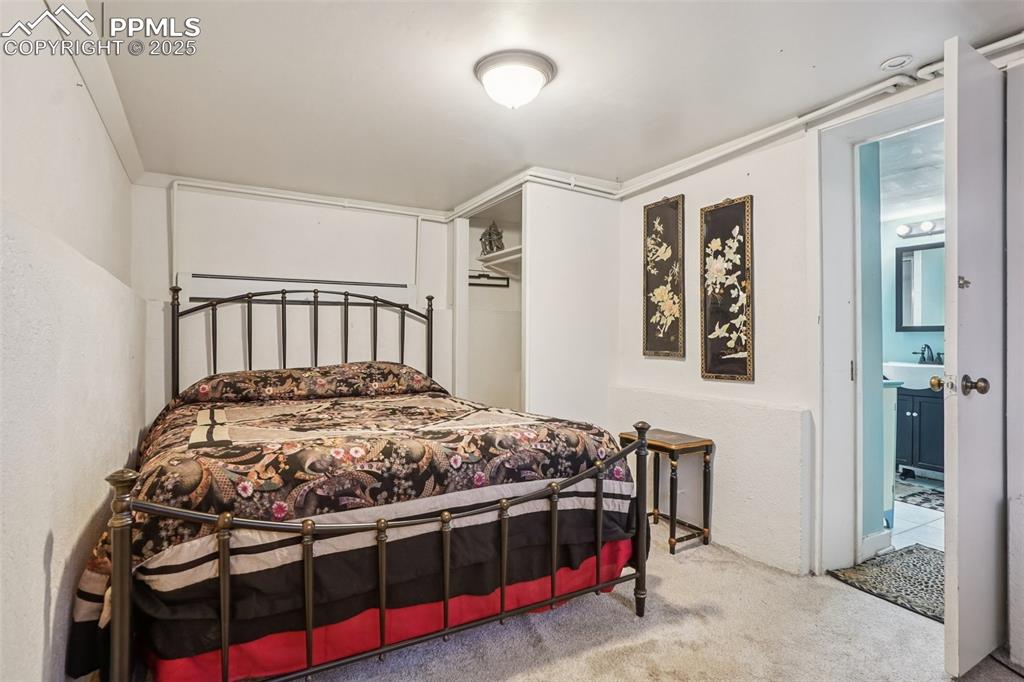 Image 33 of 43: Bedroom on the lower level with private entry/exit to yard and covered park