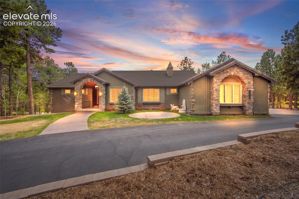 Image 1 of 42: Modern residential home featuring a stucco exterior with stone accents, arc
