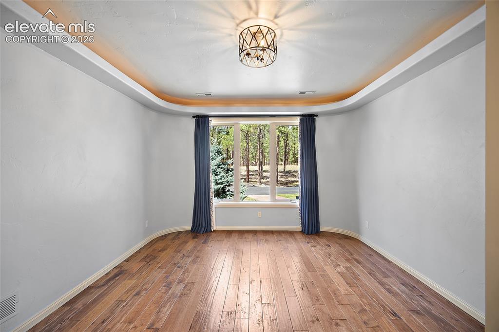 Image 16 of 42: Recessed cove lighting, a decorative ceiling fixture, wood-finish flooring,