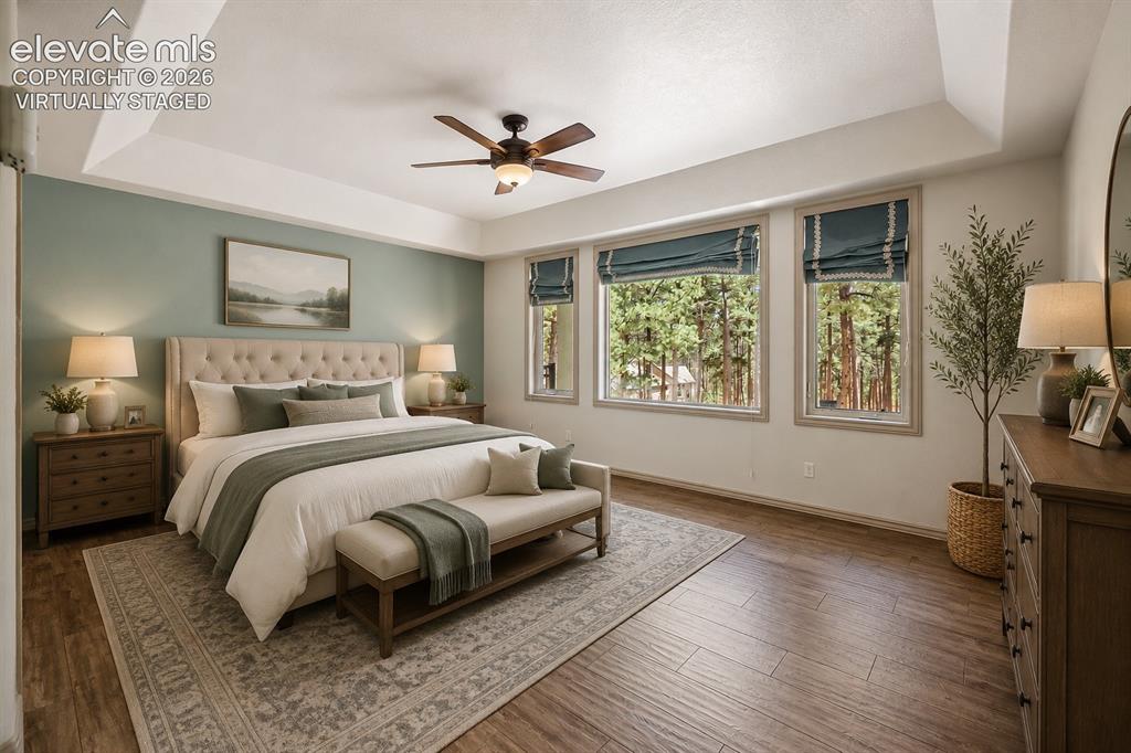 Image 36 of 42: Virtually Staged
Tray ceiling with a ceiling fan, wood-finish flooring, t
