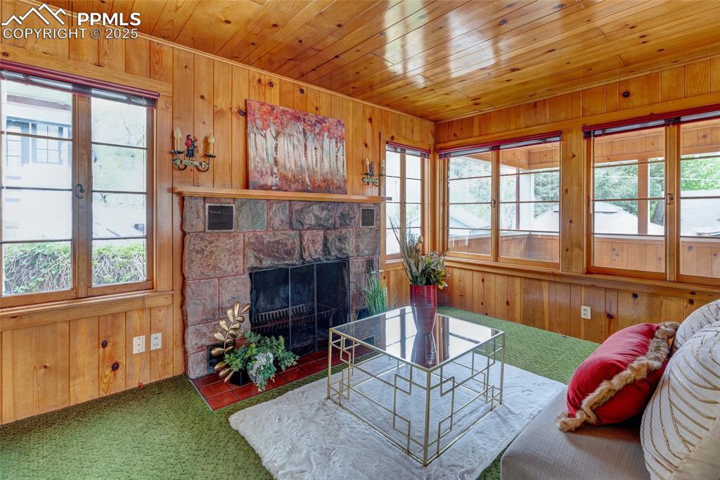Image 18 of 37: Close-up of fireplace in family room. Note the original sconces.