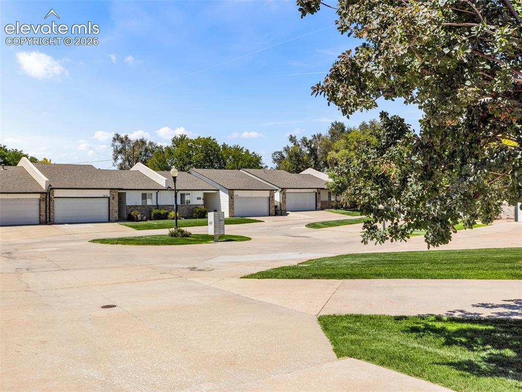 Image 8 of 9: Concrete driveways with integrated landscaping, attached garages with white