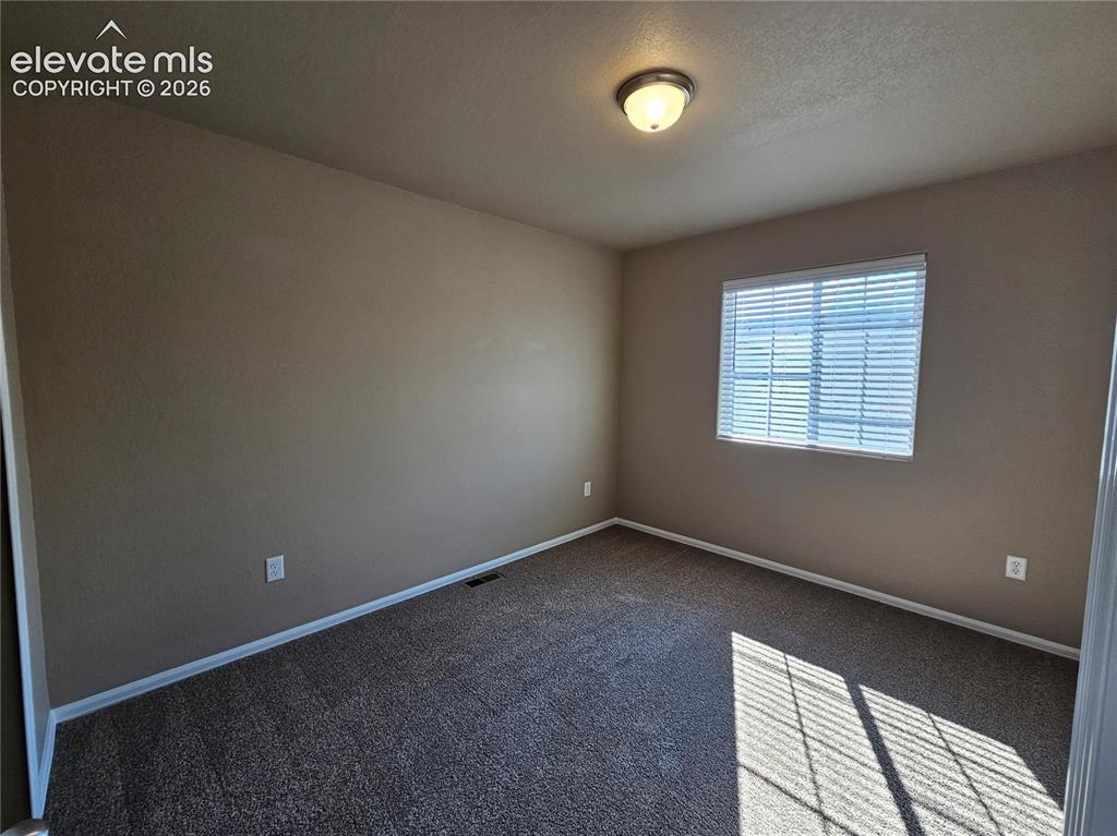 Image 14 of 20: Carpeted room featuring a window with horizontal blinds, neutral wall paint