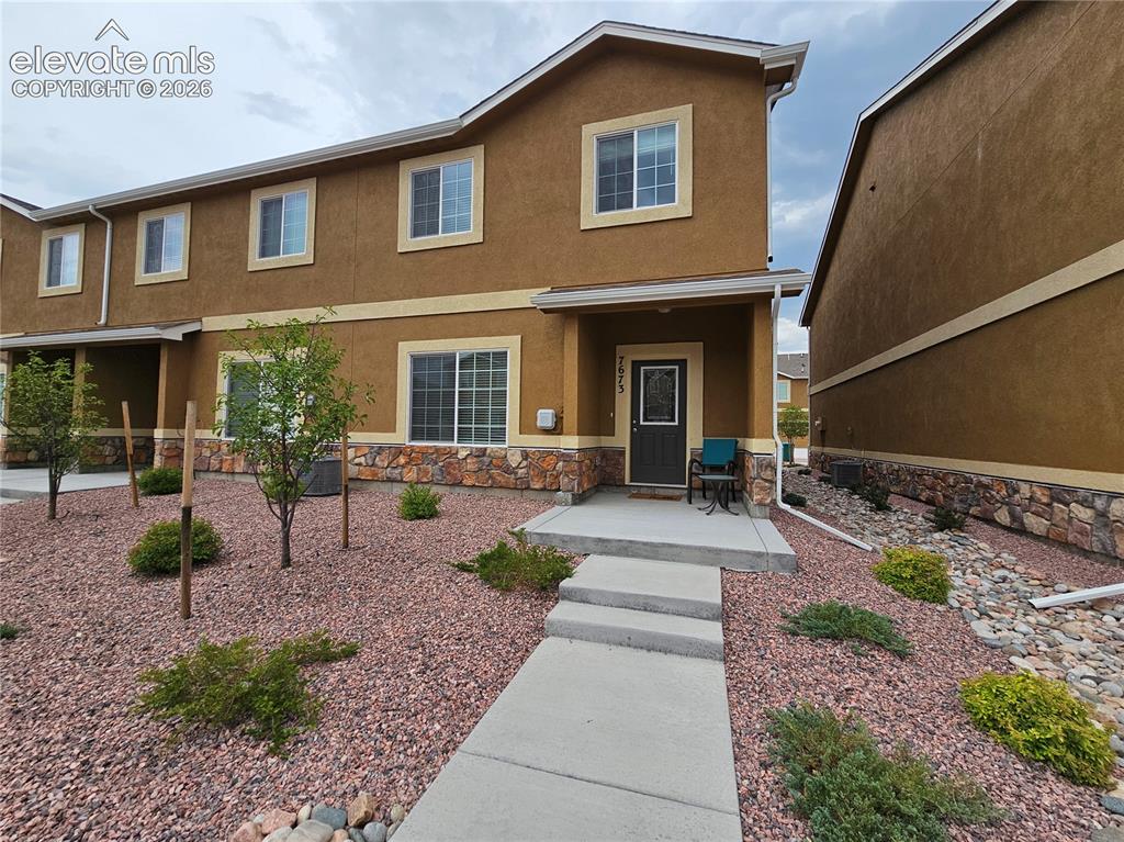 Image 2 of 20: Two-story stucco exterior with stone accents