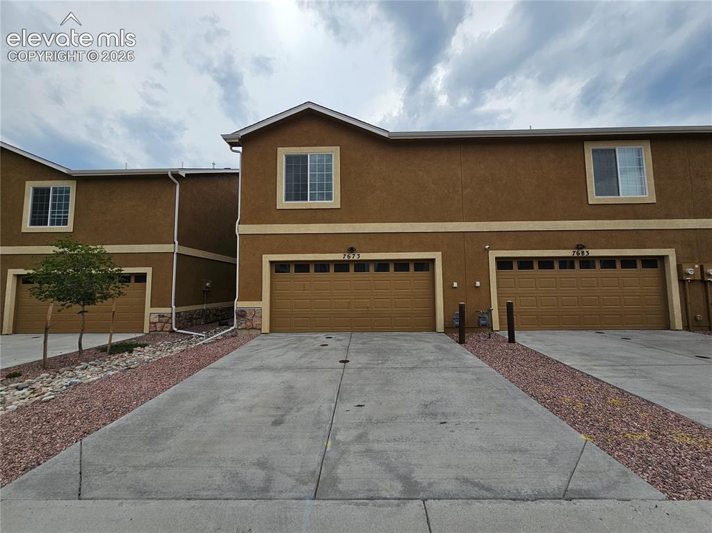 Image 20 of 20: Contemporary stucco exterior with contrasting trim, individual garage acces