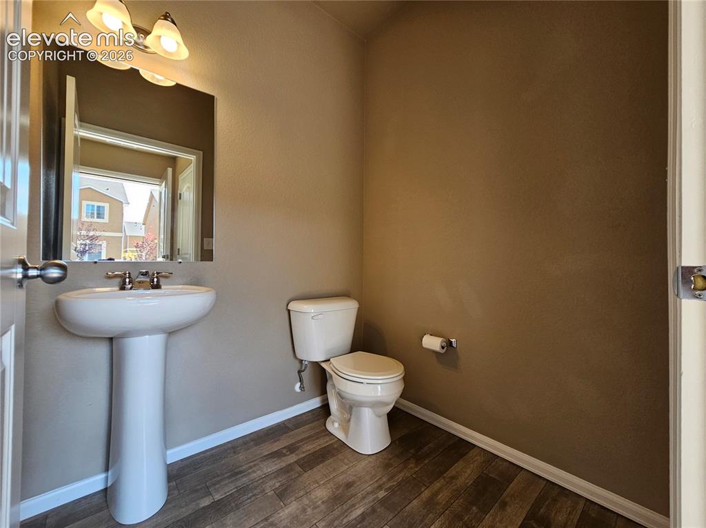 Image 3 of 20: Pedestal sink with dual-handle faucet, vanity mirror, wall-mounted light fi