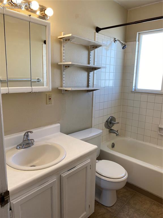 Image 12 of 15: Bathroom with toilet, vanity, shower combination,