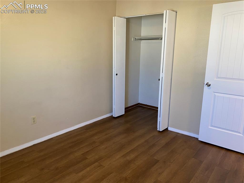 Image 13 of 15: bedroom 2 featuring dark wood-style floors, and a closet