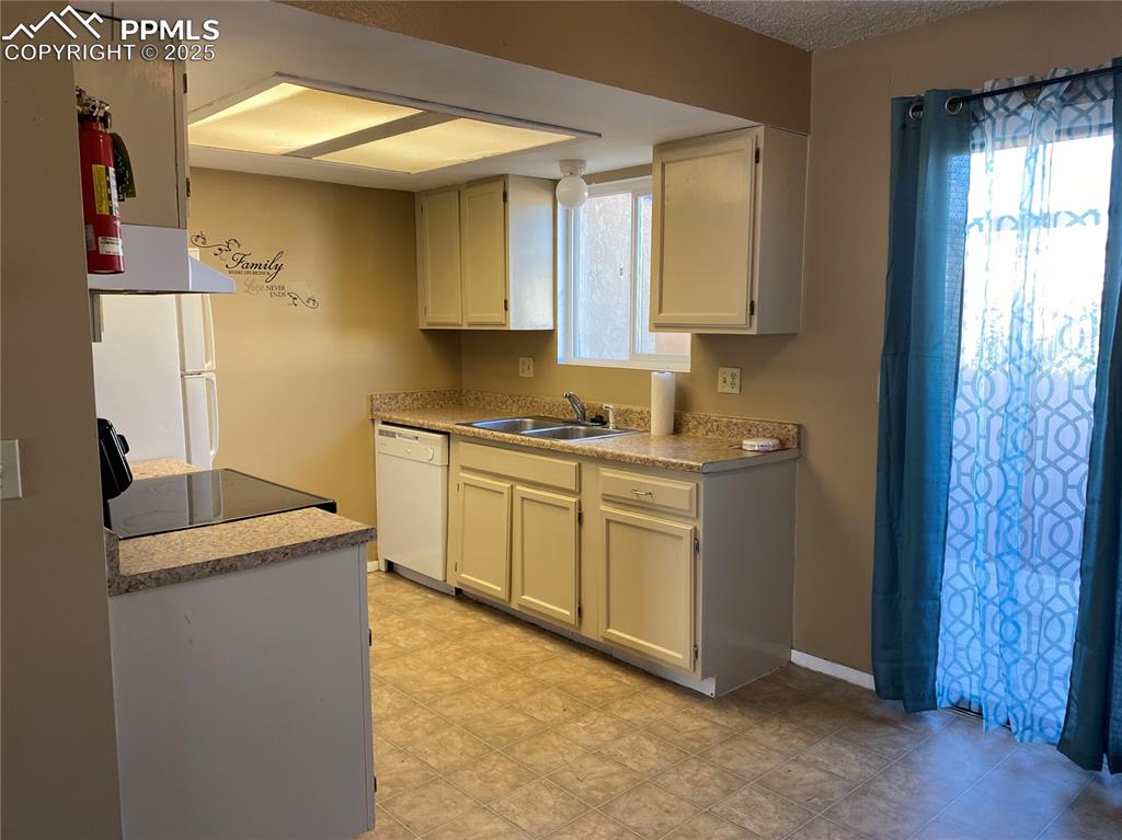 Image 3 of 15: Kitchen featuring a sink, dishwasher, range, light countertops,
