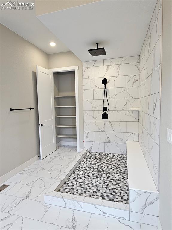 Image 10 of 20: Full bathroom featuring tiled shower, light marble finish floors, recessed 