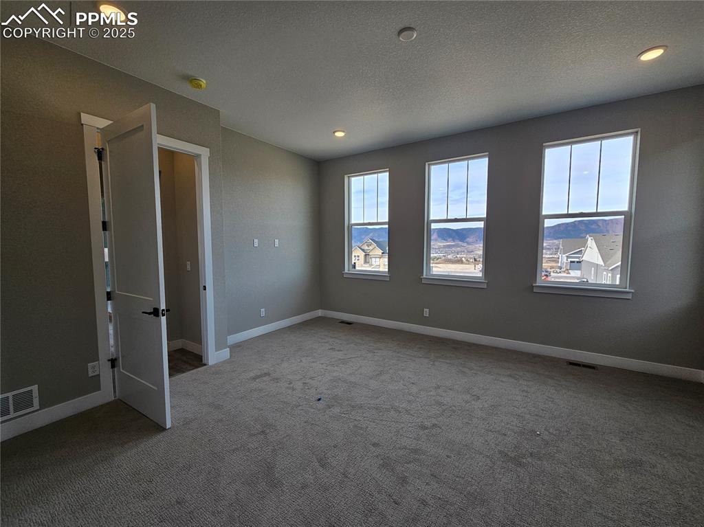 Image 13 of 20: Carpeted empty room featuring a textured ceiling and recessed lighting