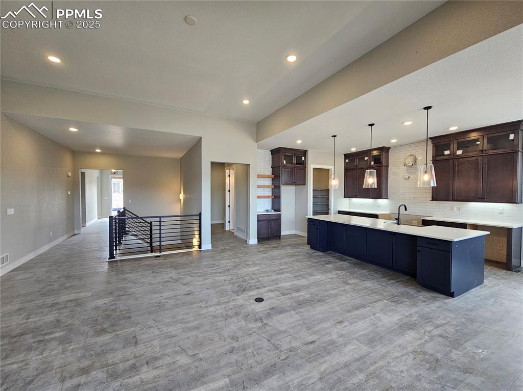 Image 14 of 20: Kitchen featuring open floor plan, decorative backsplash, a spacious island