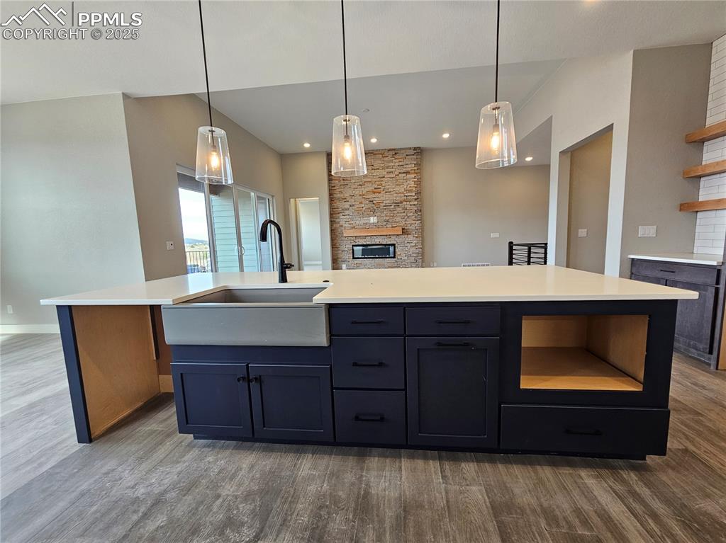 Image 17 of 20: Kitchen featuring open shelves, hanging light fixtures, dark wood finished 