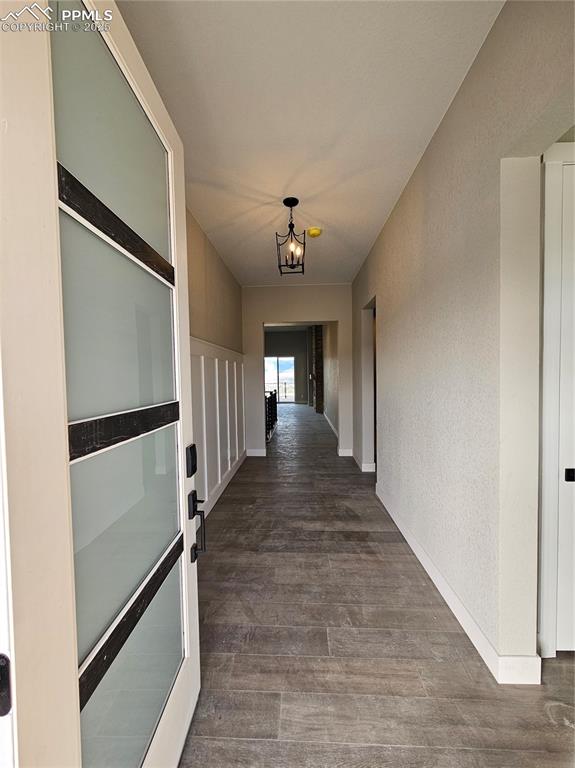 Image 3 of 20: Hall featuring dark wood-style flooring and a textured wall