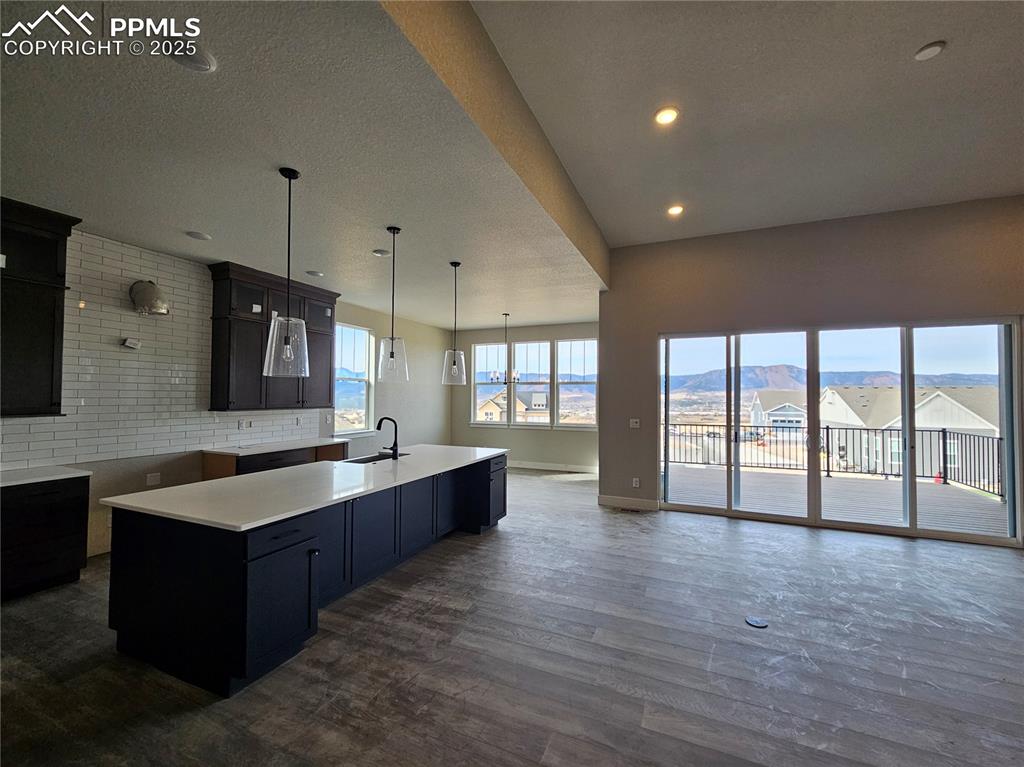 Image 4 of 20: Kitchen with decorative light fixtures, open floor plan, a textured ceiling