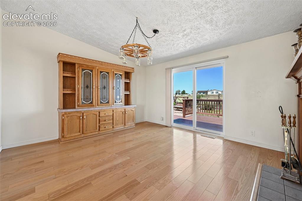 Image 14 of 38: Wood-finish flooring, built-in wooden cabinetry, fireplace with hearth, sli