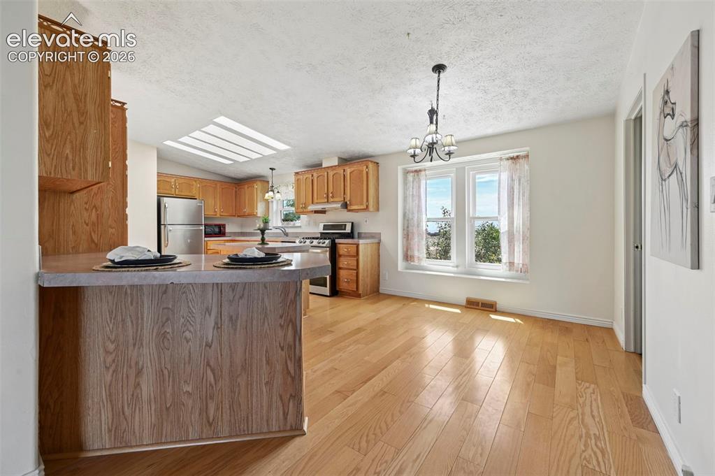Image 17 of 38: Kitchen featuring wood cabinetry, stainless steel appliances, a skylight, a
