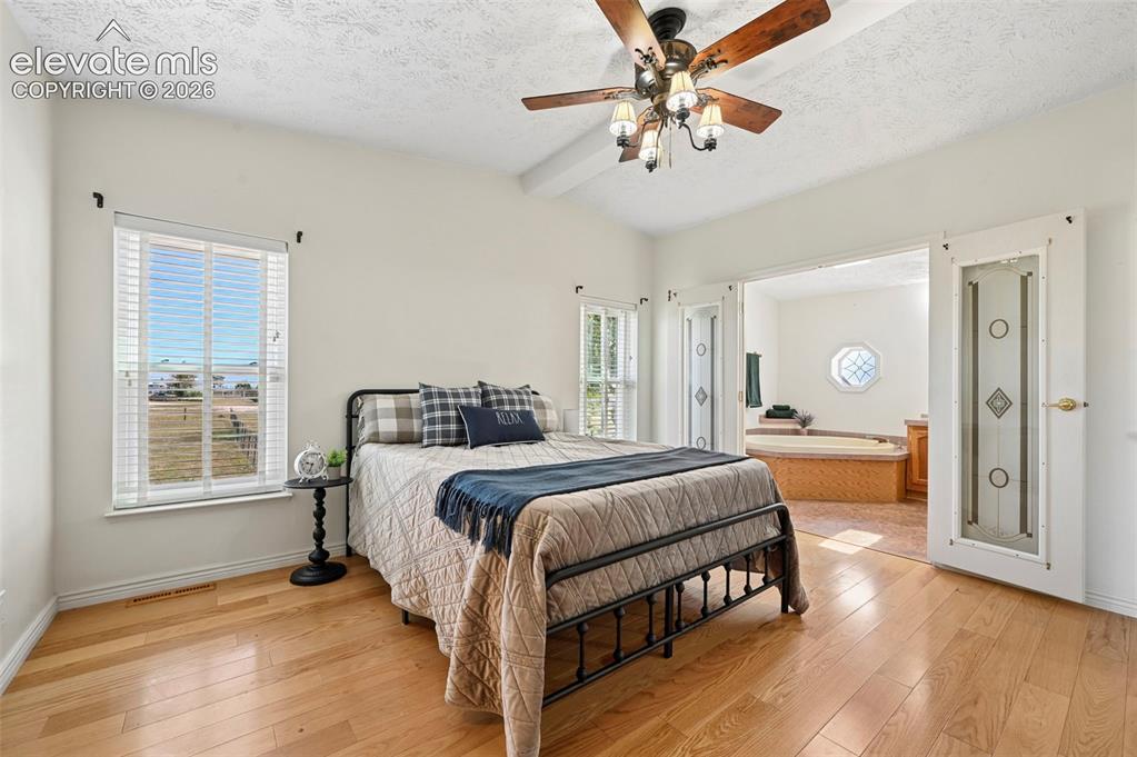 Image 20 of 38: Vaulted ceilings with a ceiling fan, light wood-finish flooring, and French