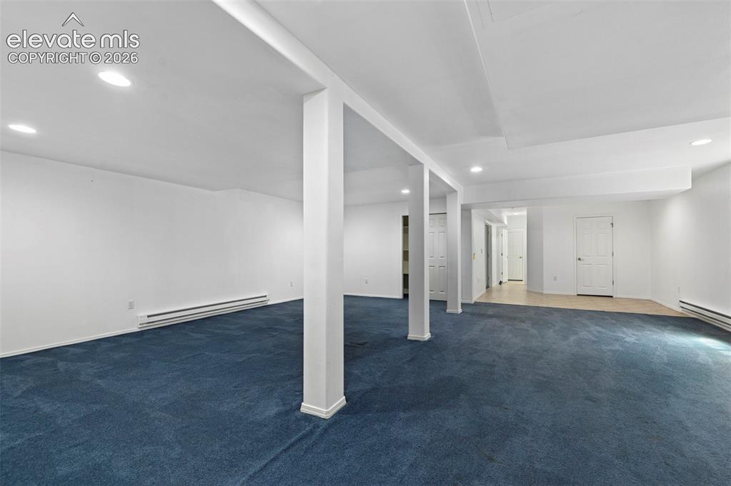 Image 25 of 38: Expansive room featuring blue carpeting, recessed lighting, white walls, an