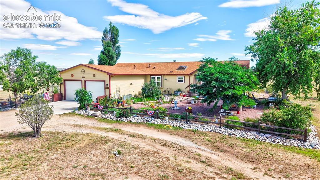 Image 34 of 38: Ranch-style residence featuring a two-car garage, earth-tone exterior, and