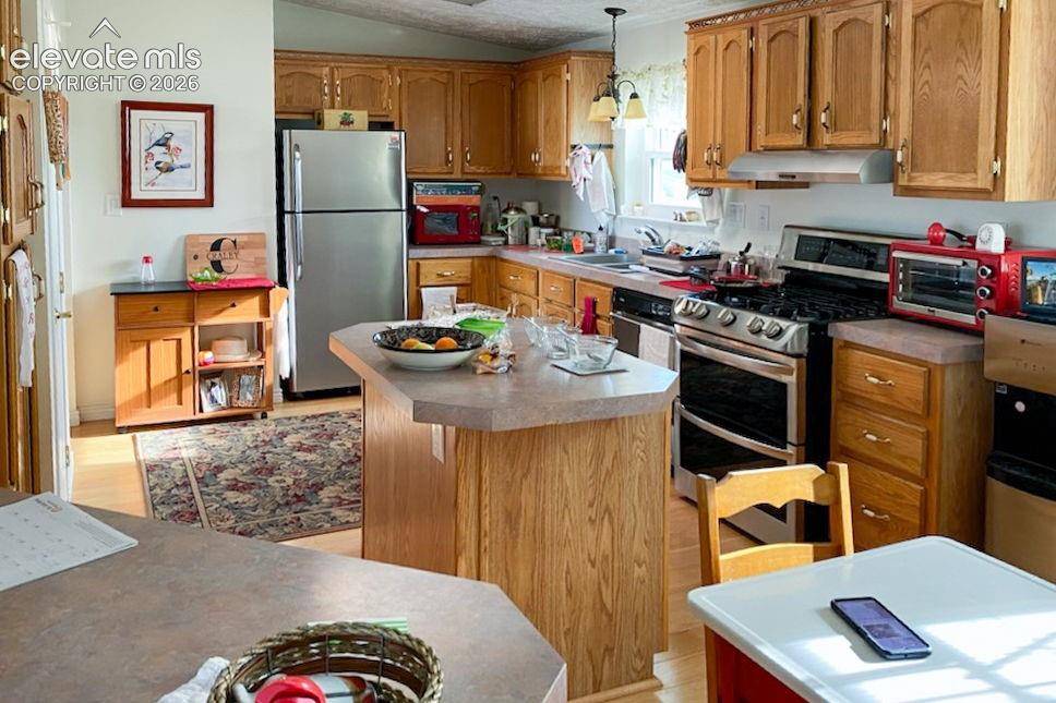 Image 6 of 15: Functional kitchen featuring a central island with a laminate countertop, w