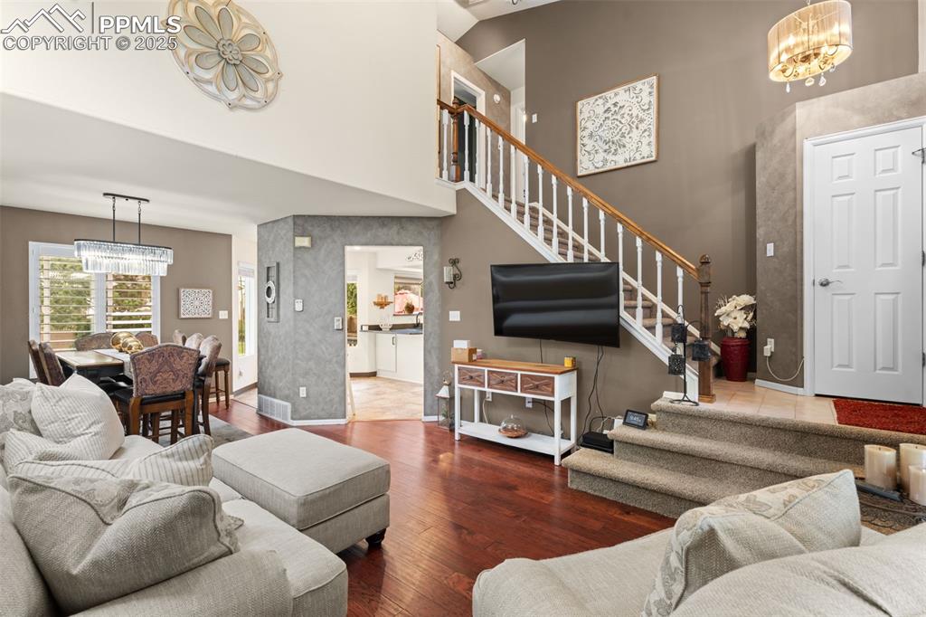Image 11 of 32: Inviting living room with soaring ceilings and a cozy gas fireplace, seamle