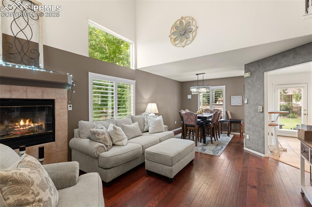 Image 12 of 32: Living area with a towering ceiling, hardwood / wood-style floors, and a ti