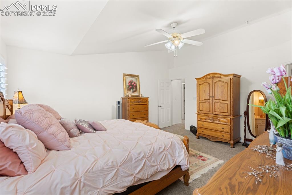 Image 14 of 32: Bedroom featuring light colored carpet, lofted ceiling, and ceiling fan