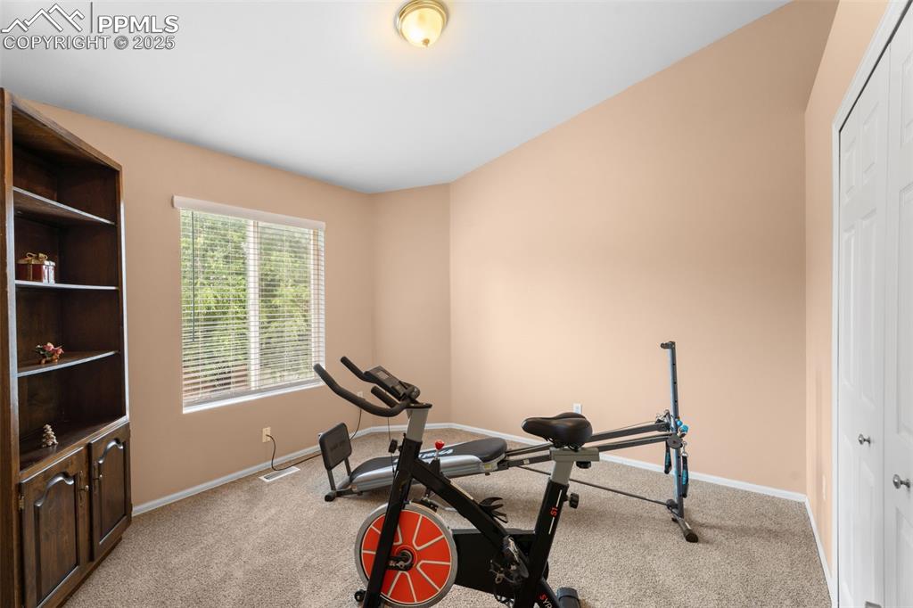 Image 17 of 32: Workout room with light carpet and baseboards