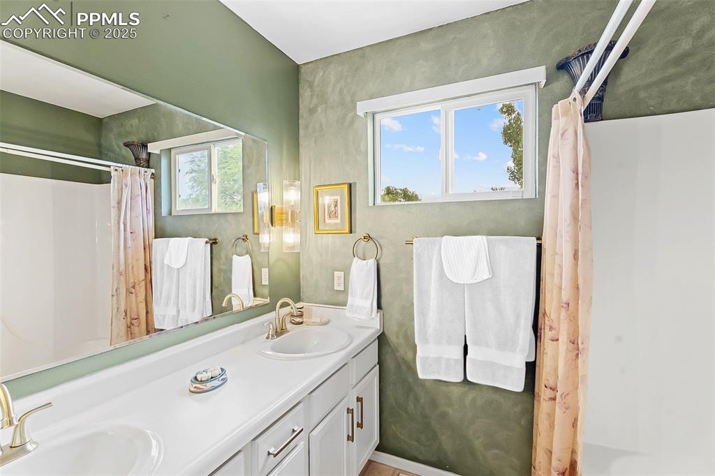 Image 18 of 32: Second floor bathroom featuring double vanity with new hardware.