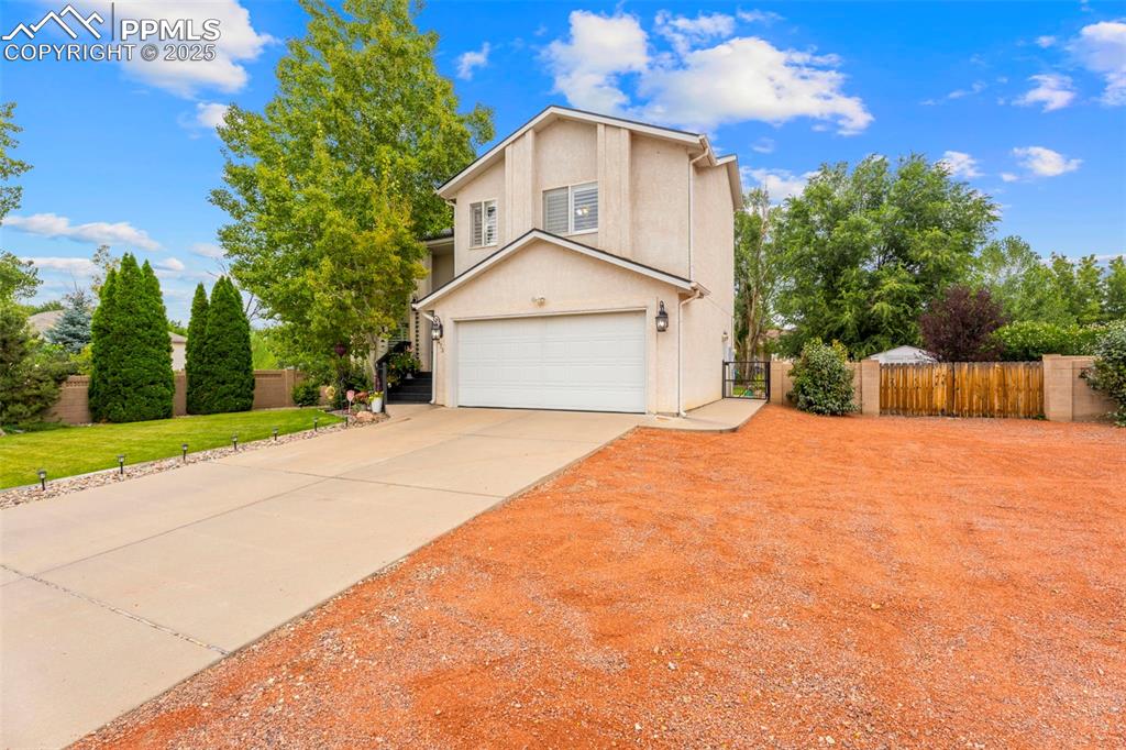 Image 2 of 32: Traditional-style house with a garage, driveway, and stucco siding