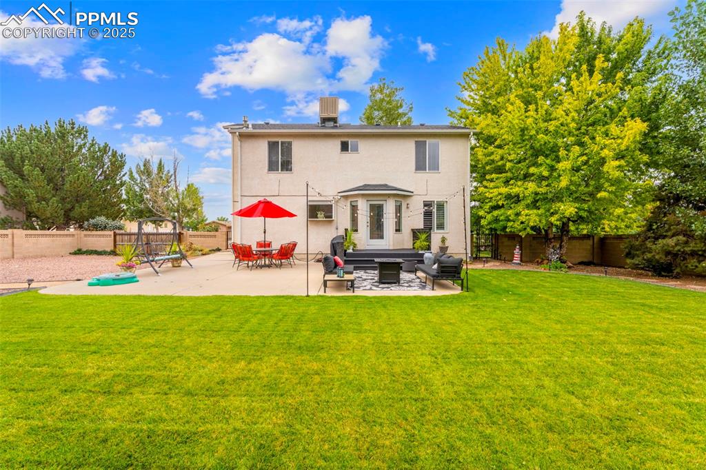Image 23 of 32: Beautiful backyard oasis featuring lush, green grass that looks like turf,