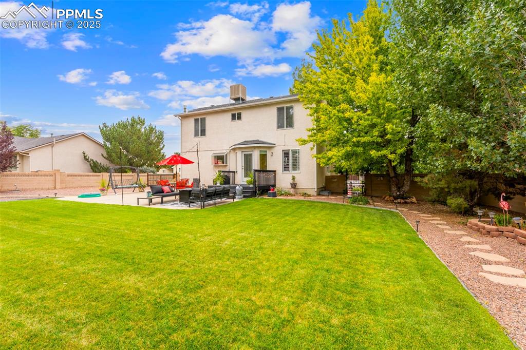 Image 24 of 32: Rear view of house with an outdoor hangout area, a patio area, and a fenced
