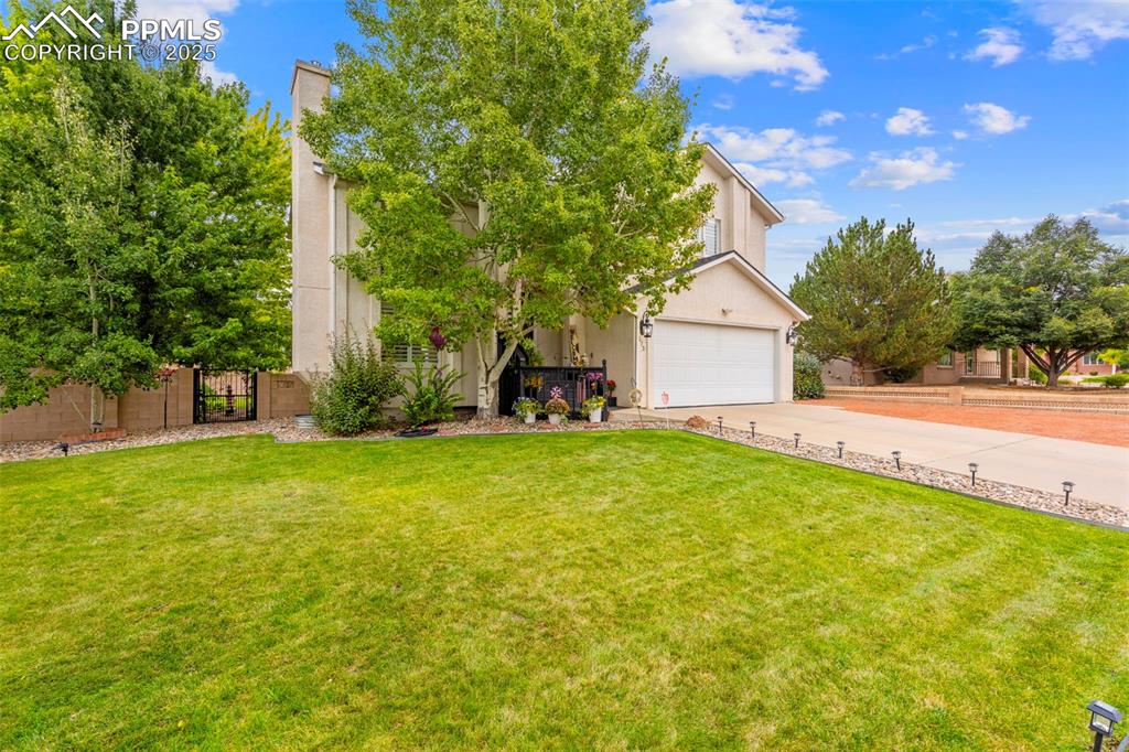 Image 3 of 32: Obstructed view of property with concrete driveway, stucco siding, a gate,
