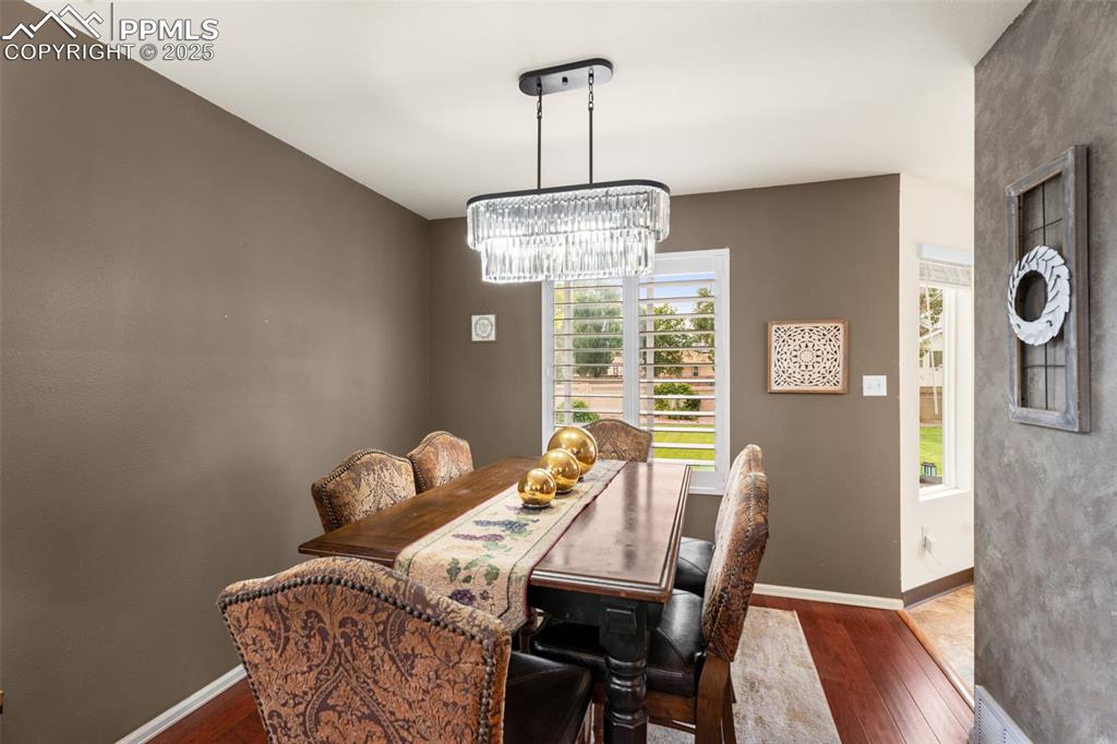 Image 5 of 32: Dining space with dark wood-type flooring and a chandelier
