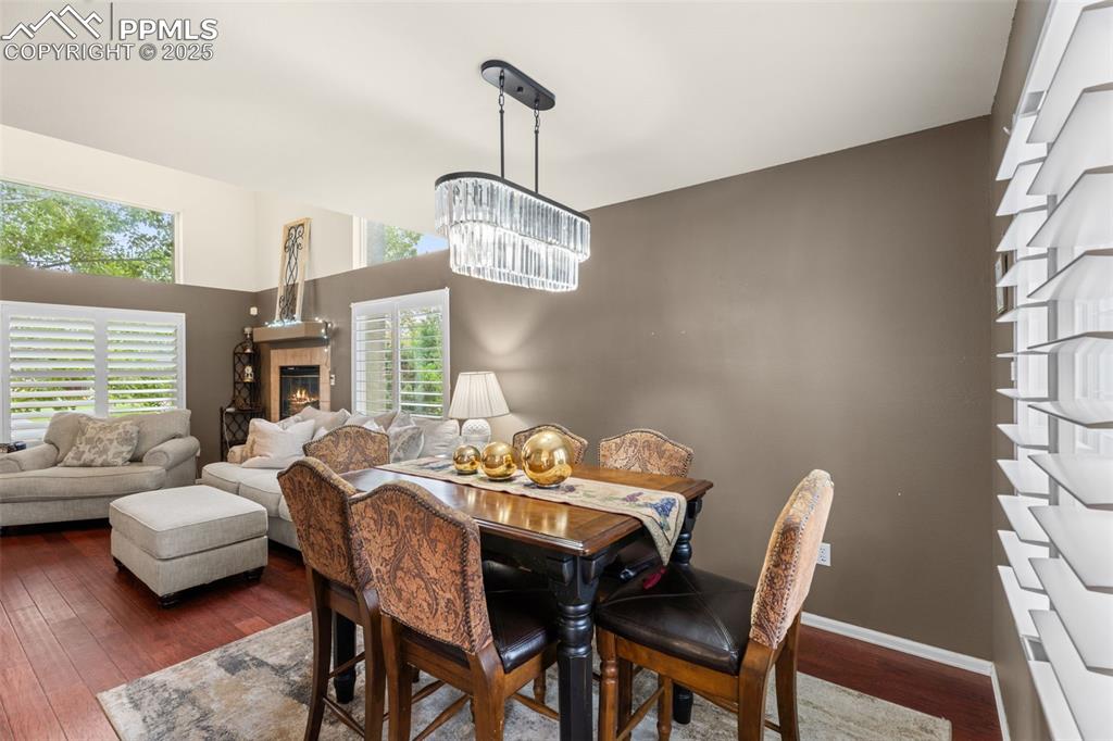 Image 6 of 32: Dining space featuring dark wood-type flooring and a tile fireplace