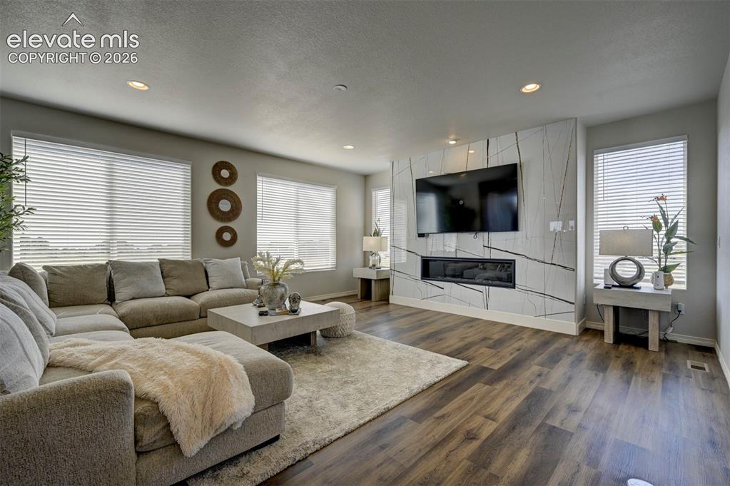 Image 10 of 45: Spacious living area featuring wood-finish flooring, recessed lighting, and