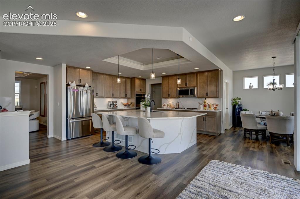 Image 13 of 45: Contemporary kitchen featuring an oversized island with a waterfall-edge co