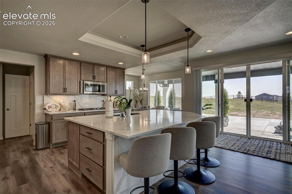 Image 14 of 45: Kitchen featuring an expansive island with seating for three, stainless ste