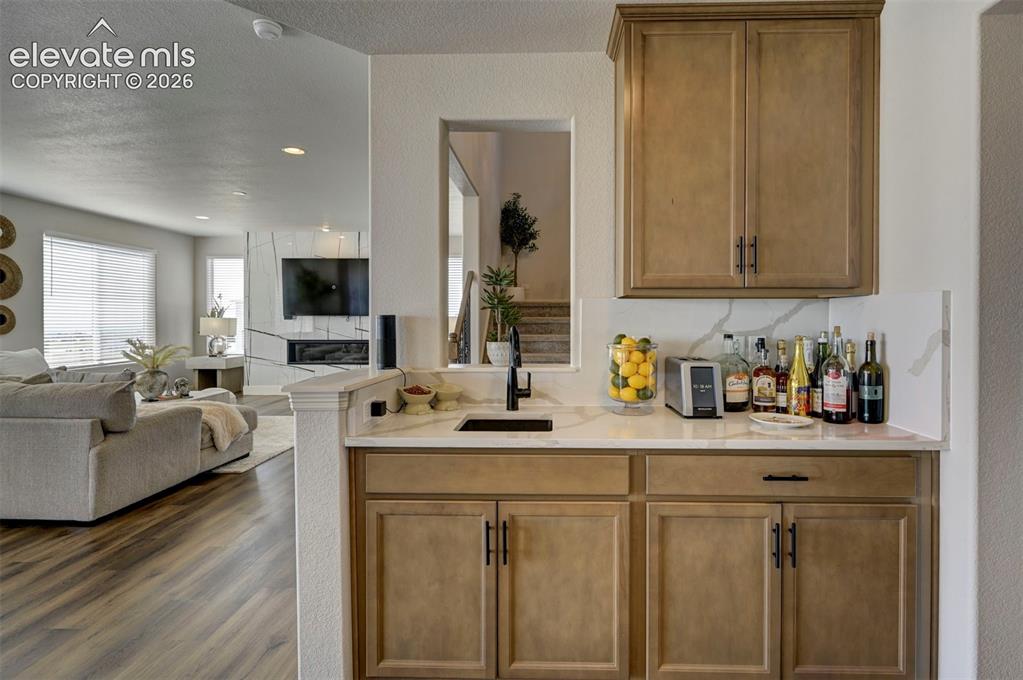 Image 15 of 45: Built-in beverage station featuring light wood-finish cabinetry, a white co