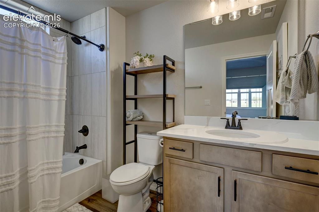 Image 27 of 45: Bathroom featuring a light-toned wood-finish vanity with a white countertop