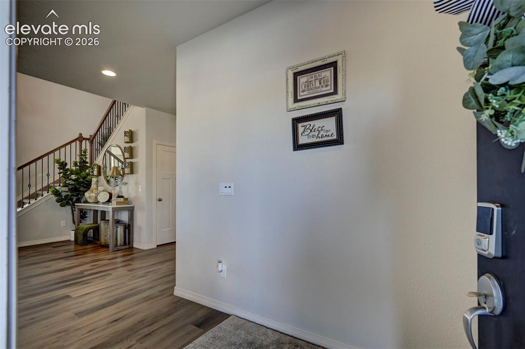 Image 3 of 45: Entryway featuring wood-finish flooring, a contemporary staircase with wrou