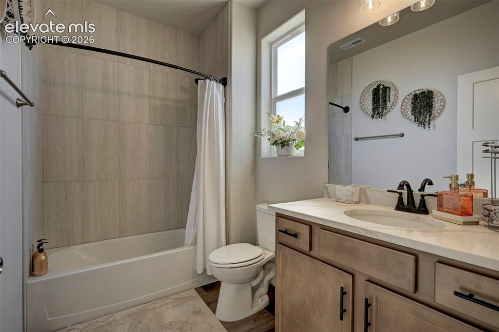 Image 30 of 45: Bathroom featuring a white bathtub with subway tile surround, a single vani