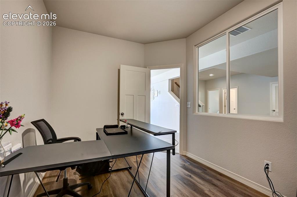 Image 34 of 45: Dedicated room with wood-finish flooring, light-toned wall paint, white tri